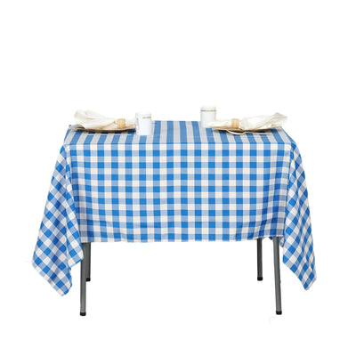 Blue and white checkered tablecloth with plates and napkins on a table