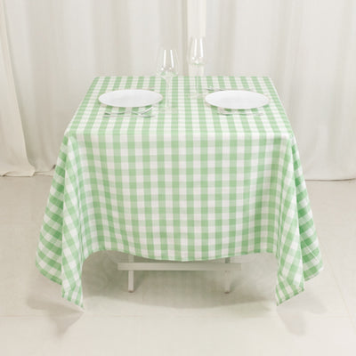 Green and white checkered tablecloth on a dining table with plates.