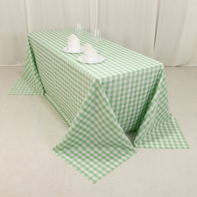 Green checkered tablecloth draped over a table with plates and napkins.