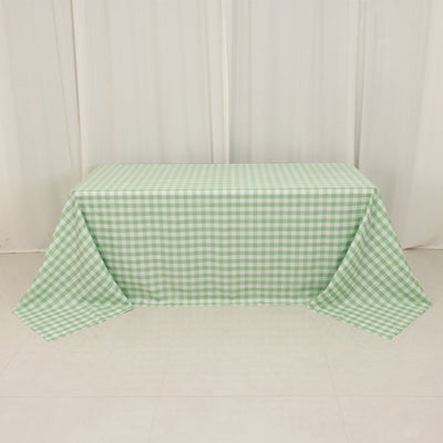Green gingham tablecloth draped over a table in a studio setting