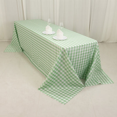 Green checkered tablecloth draped over a table with plates and glasses.