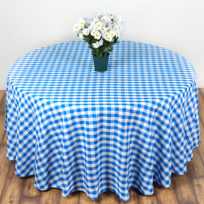 Blue and white checked tablecloth draped over a round table with flowers.
