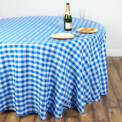 Blue and white checkered tablecloth on a round table with glasses and plates.