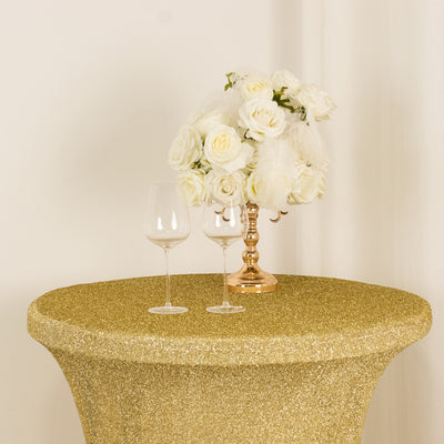 Gold glitter table with white roses and two wine glasses.