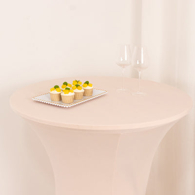 Cupcakes on a plate with two wine glasses on a round table.
