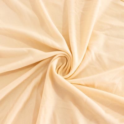 Soft beige fabric with a smooth texture in a swirling pattern.