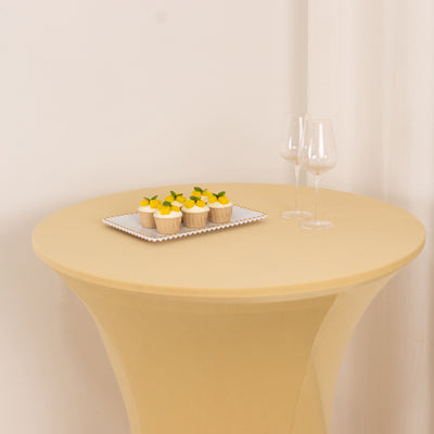 Elegant round table with cupcakes and wine glasses on a neutral backdrop.