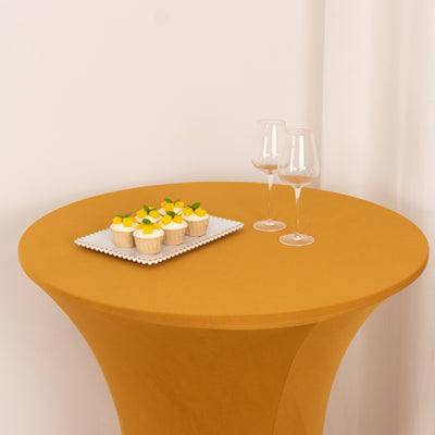 Round mustard table with cupcakes and two glasses.