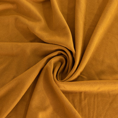 Soft mustard yellow fabric in a swirling pattern, showcasing its texture.