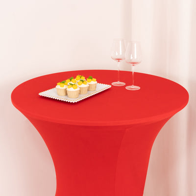 Red table with cupcakes and wine glasses on a white backdrop.
