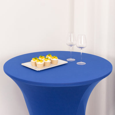 Blue table with cupcakes and two wine glasses.
