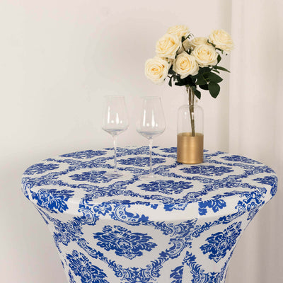 Blue and white patterned table with glasses and roses in a vase.