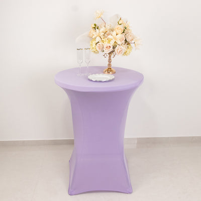 Purple cocktail table with floral arrangement and glasses on a plain backdrop.