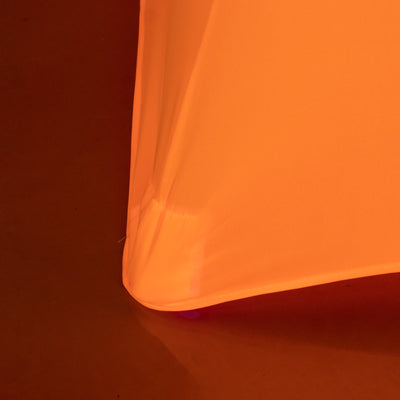 Orange fabric draping with visible texture in a studio setting.