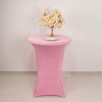 Pink cocktail table with floral arrangement and champagne flutes on top.