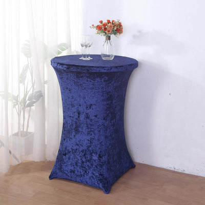 Elegant navy blue table cover on a tall round table with floral arrangement.