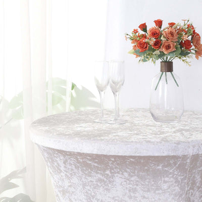 Elegant round table with flowers and glasses in a bright, staged setting.