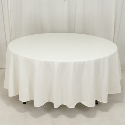 Round white table with a draped tablecloth