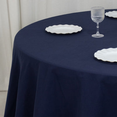 Navy blue tablecloth with white decorative plates and a glass