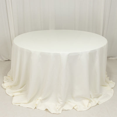Round white table covered with a draped tablecloth.