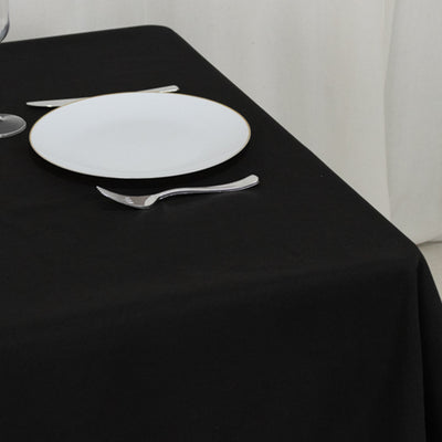 Elegant black table setting with a white plate and cutlery.