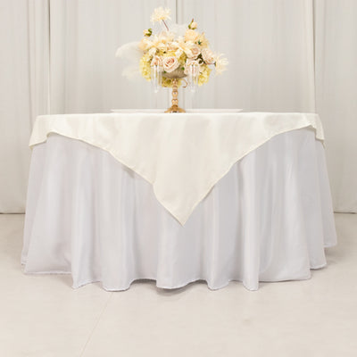 Elegant white tablecloth draped over a round table with floral centerpiece.