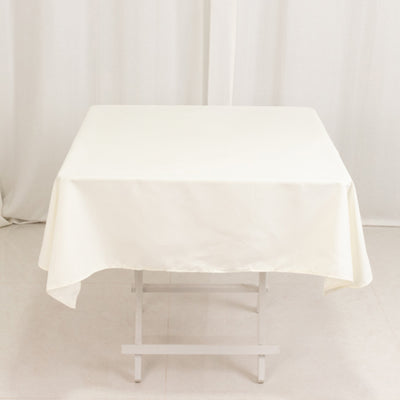 White tablecloth draped over a folding table in a studio setting.