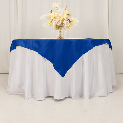 Blue tablecloth draped elegantly over a white table with a floral centerpiece.
