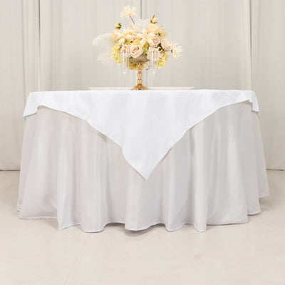 Elegant white tablecloth draped over a round table with floral centerpiece.