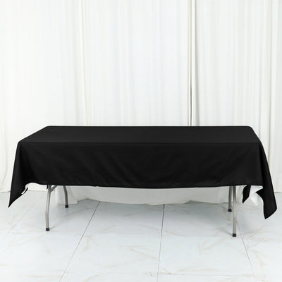 Black tablecloth draped over a folding table in a studio setting.