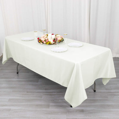 Elegant light green tablecloth draped over a table with decorative plates and floral centerpiece.