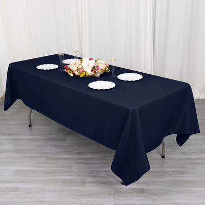 Navy blue tablecloth draped over a table with plates and floral centerpiece.