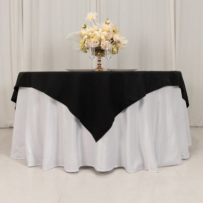 Elegant table setting with black and white tablecloth and floral centerpiece.