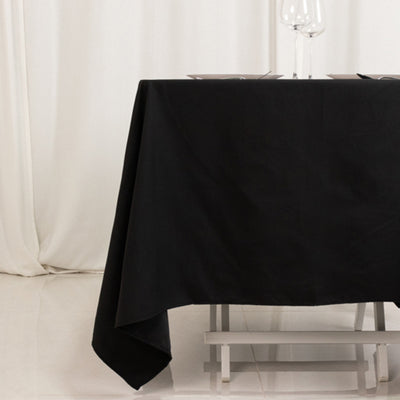 Black tablecloth draped over a table in a minimalistic setting.