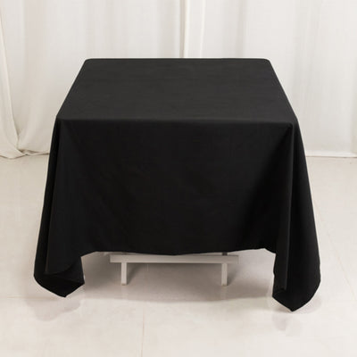 Black tablecloth on a white table in a studio setting.