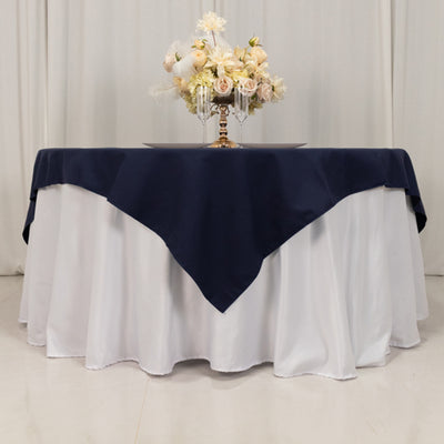 Elegant navy tablecloth draped over a white table with floral centerpiece.