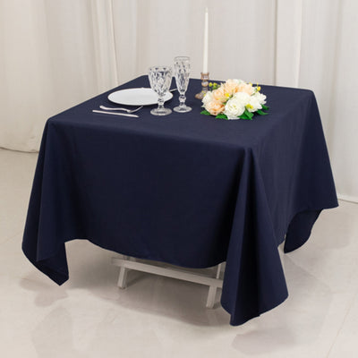 Navy tablecloth on a table set with glassware and flowers for a dining scene.