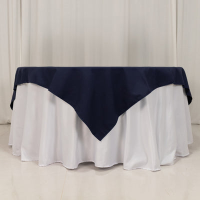 Navy tablecloth draped over white table for elegant dining setup.