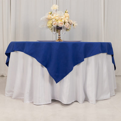 Elegant table setup with blue tablecloth and floral centerpiece.