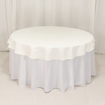 Round white tablecloth with scalloped edges, elegantly draped.