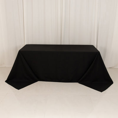 Black tablecloth draped over a table in a studio setting.