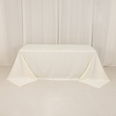 Empty table with cream tablecloth in a studio setting.