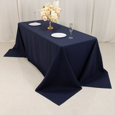 Navy blue tablecloth draped over a table set with plates and glasses.