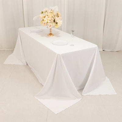 Elegant white table with floral centerpiece and glassware setup for events.