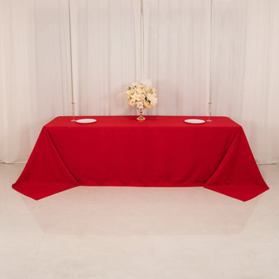 Red tablecloth draped elegantly on a table with floral centerpiece.
