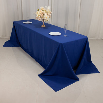 Navy blue tablecloth draped over a long table with plates and glassware.