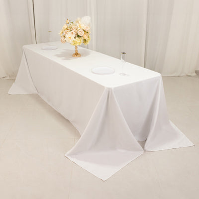 White tablecloth draped on a banquet table with floral centerpiece.