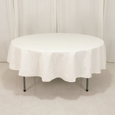 Round white table with a draped tablecloth