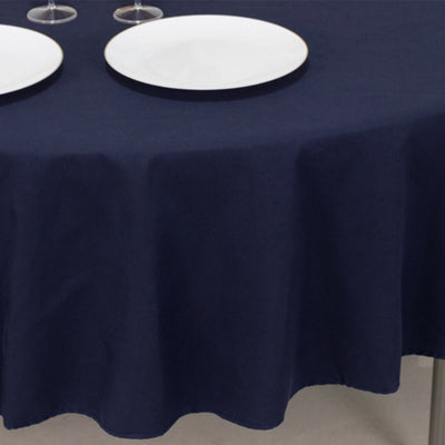 Navy blue tablecloth with white plates set on a round table.