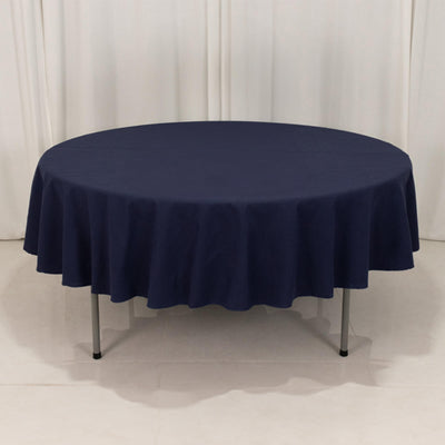 Round navy tablecloth draped over a table in a studio setting.